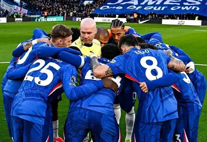 Судья окружен игроками «Челси», которые выступают с мотивирующей речью.