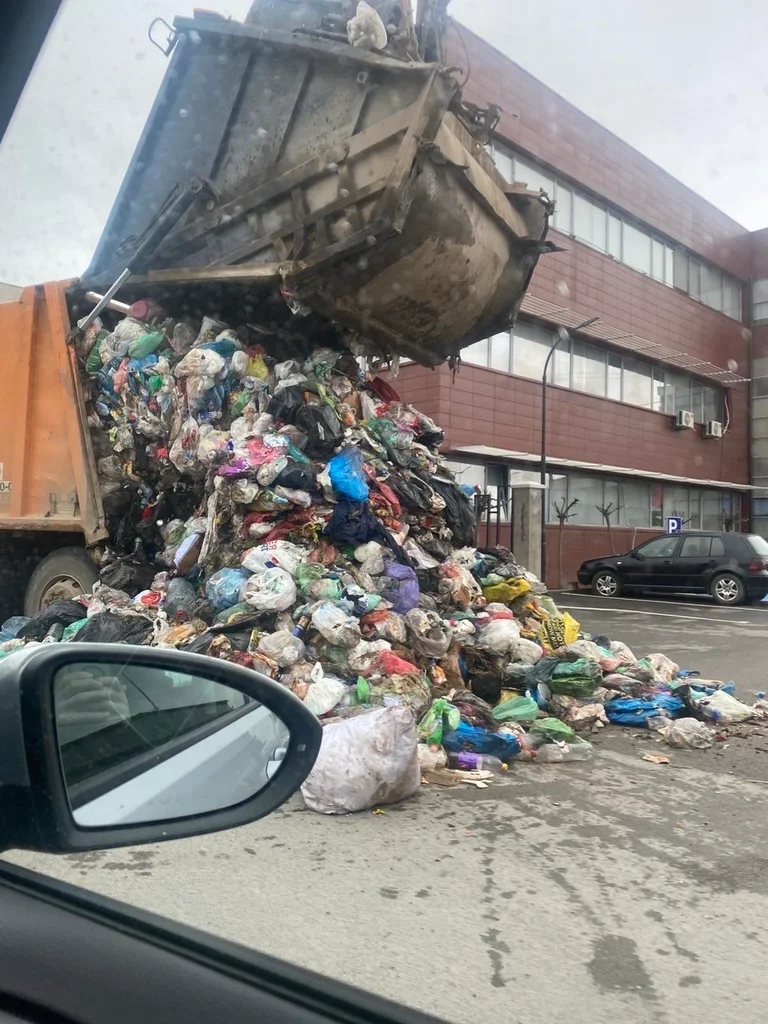 Oczyszczanie odpadów z samochodów ciężarowych przed budynkiem gminy Fusha Kosowo