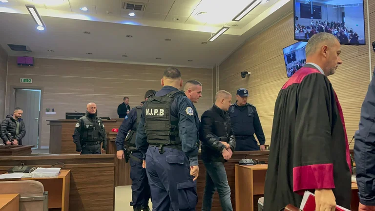 Sota seguretat estricta, Naim Mursel i altres entren a la sala de judicis.
