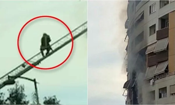 Firefighter מציל את הילד מלהבות בבית טירנה, לוקח אותו בסולם בזרועותיו