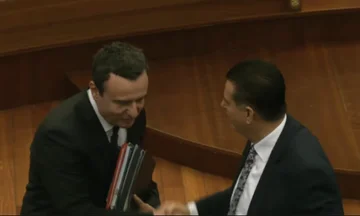 Kurt vstopi v zborsko dvorano, se rokuje z Bahthirjem in drugimi.