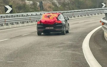 Z rdečimi in črnimi zastavami ter simboli KLA, avtomobili iz Kosova proti Albaniji