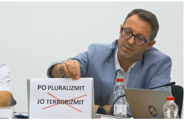 Albulen Hadziu make gör en show på CEC, kommer ut med en slogan: Vad sägs om pluralism, inte terrorism?