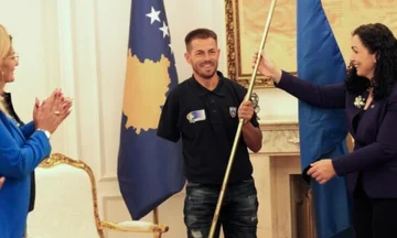 Kosovo-Präsident Grevist Bytyqi Hände über die Flagge des Kosovo