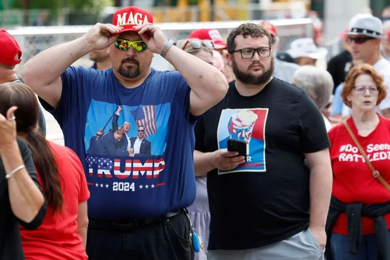 I partecipanti al Trump rally indossano camicie con la sua immagine dietro l'assassinio