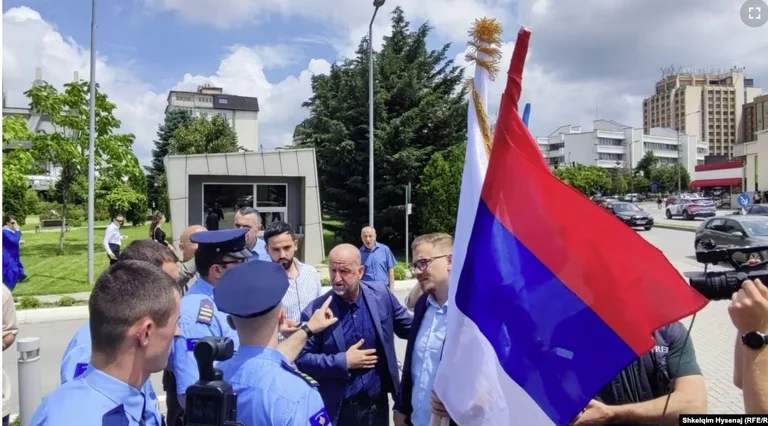 Un politicien serbe place brièvement les drapeaux communautaires devant le bâtiment du gouvernement