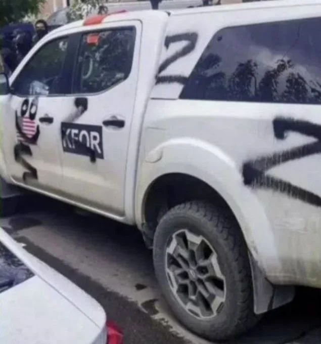 Los manifestantes serbios colocan inscripciones de símbolo de guerra ruso en Ucrania en el vehículo de la KFOR estadounidense