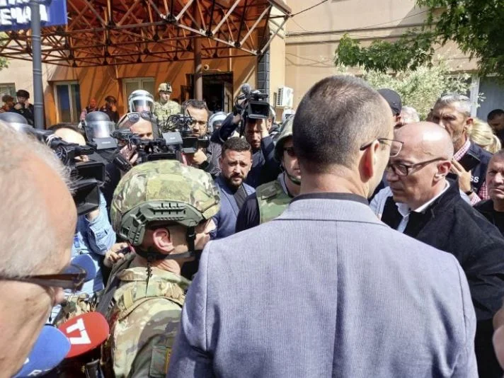 Los serbios se niegan a dar paso a dos vehículos de policía en Zvecan, soldados de la KFOR hablando con Rakiqi
