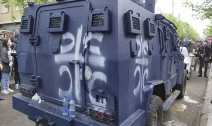 Los manifestantes dibujan símbolos nacionalistas en el vehículo policial
