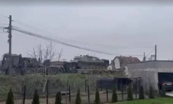 KFOR military vehicles column to northern Mitrovica, helicopter trailing high