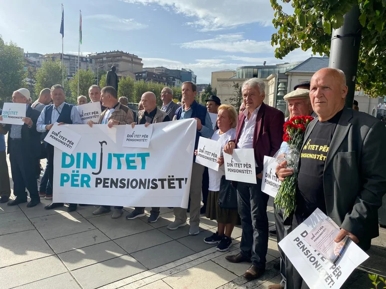 Pensioners wait with flowers and placards, demand change of law