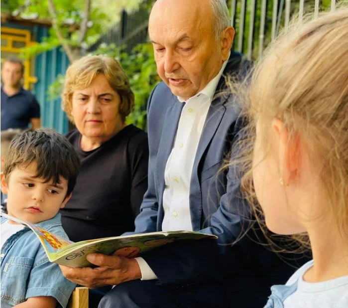 Isa Mustafa lit des contes aux enfants dans le jardin