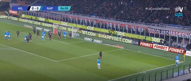 Il giocatore di Napoli manda la palla insieme al portiere di Milano