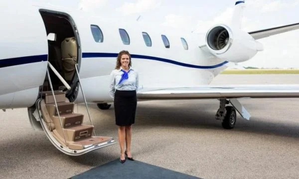 Pse stjuardesat i mbajnë duart pas shpinës kur pasagjerët futen në aeroplan?