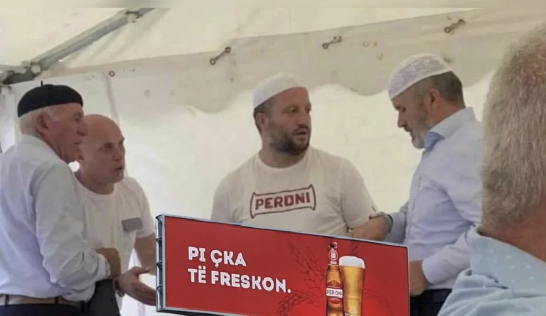 Hoxha von Mitrovica trägt Hemden mit Bier-Logo und sagt: “Pi*ka erfrischende”