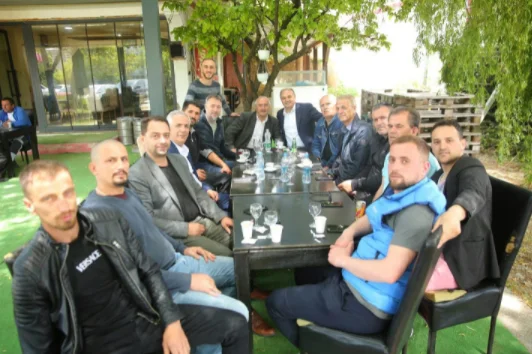 Hoxhaj sotto la compagnia di Lushtaku, Xhemajli e Nura godono di un caffè a Runik