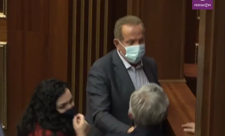 As Pacolli enters the hall, Osman takes him to a corner for consulting
