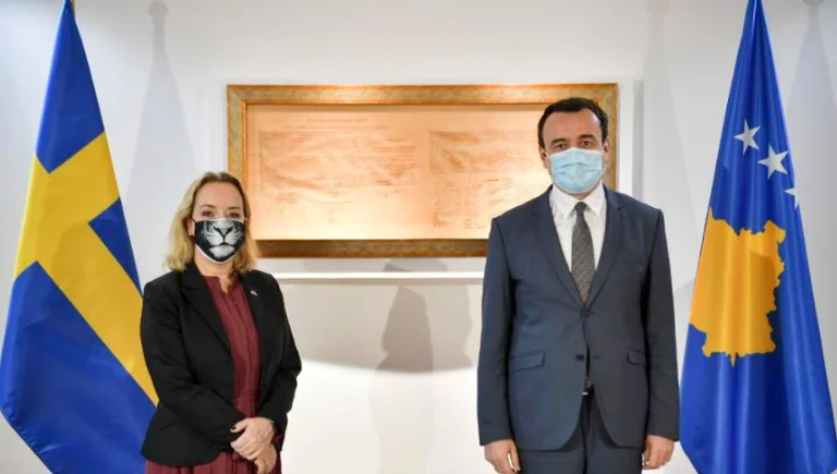 Kurt trifft sich mit dem schwedischen Botschafter, der eine Tiger-Design Maske trägt