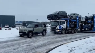 El camión de 44 toneladas que transporta Land Rowera pegado en la calle, el empleado usa uno para sacarlo