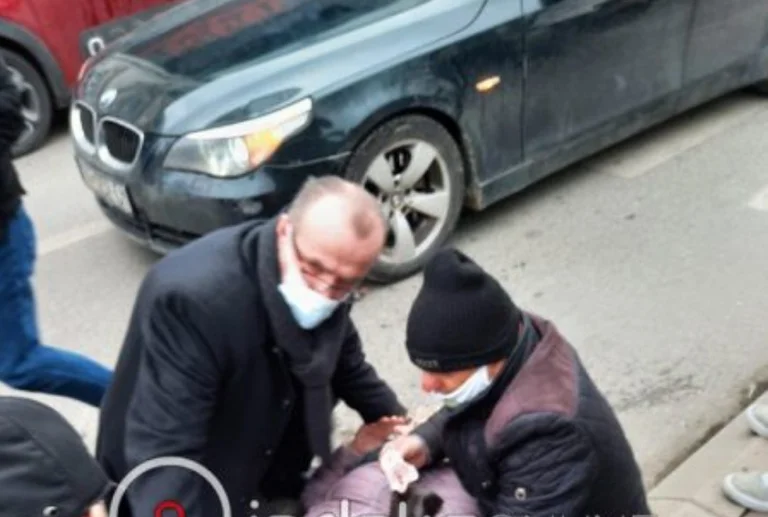 Kamishi hilft der Frau, die mit dem Auto in Pristina getroffen wurde, ihre erste Hilfe