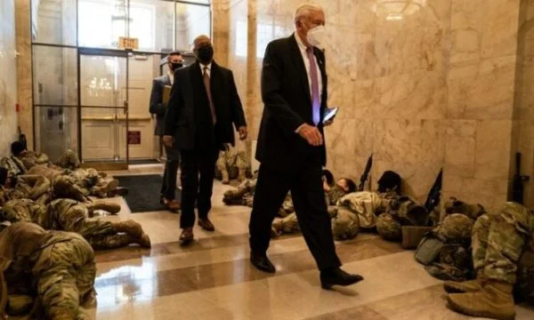 Congressmen walk beside members of the National Guard who are sleeping in Congress halls