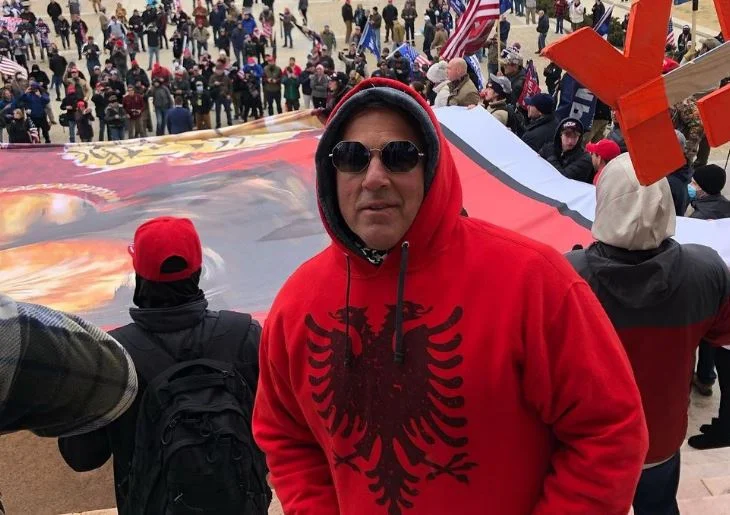 Albanés para dirigir la protesta contra Trump, con águila en el pecho