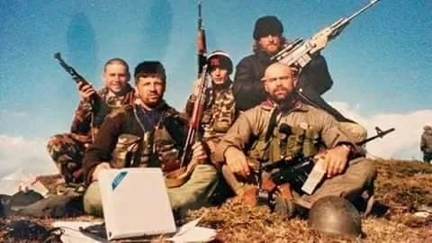 War photo where Nazim Haradinaj hangs the cross donated by a Catholic soldier