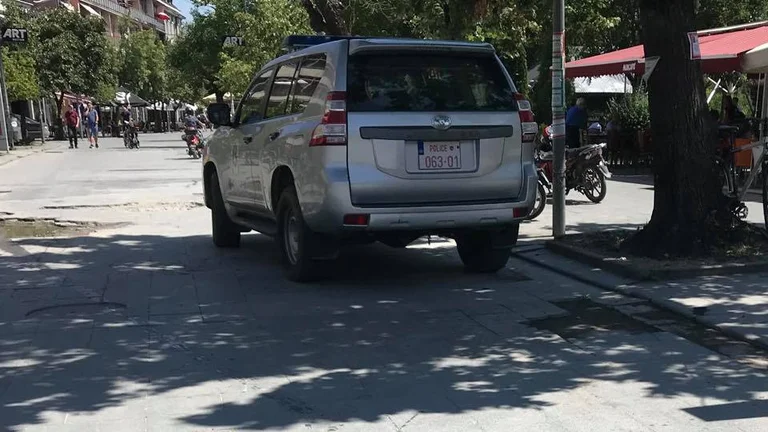 Kosovo police park their car in the square, make sure it doesn't shine