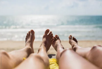 How can you treat feet and dry skin before the beach?