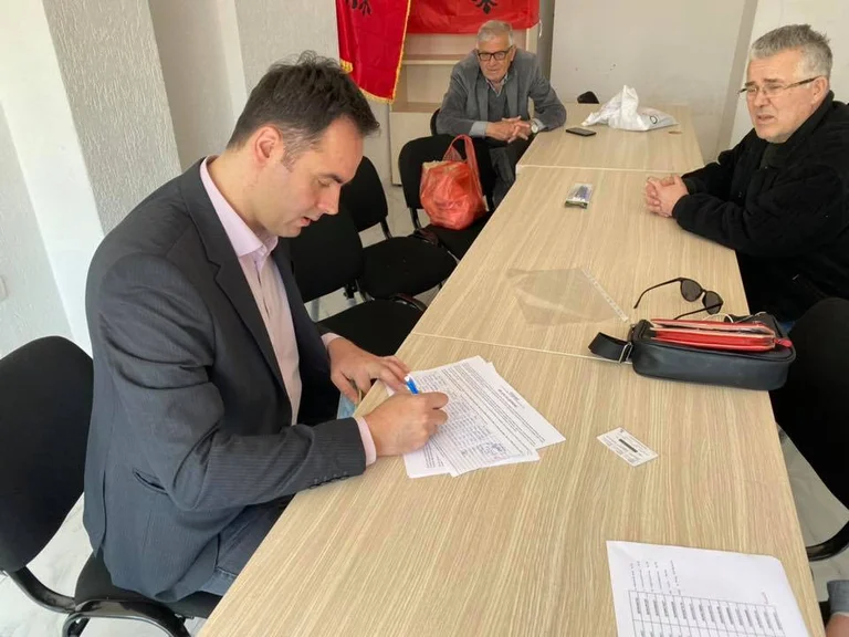 Konjufca nënshkruan peticionin në një zyre të çuditshme ku ndodhen dy flamuj të Shqipërisë