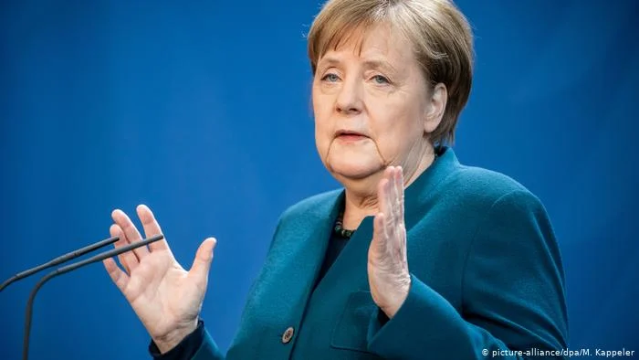 Vita - minaccioso Merkel, rose rosse, e candele su una lapide