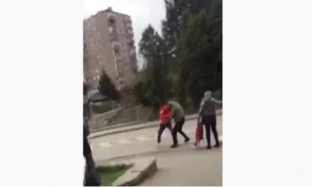 Men and women fight each other for a sack of flour