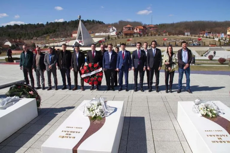 Istref and fellow workers pay their respects near Jashar family graves