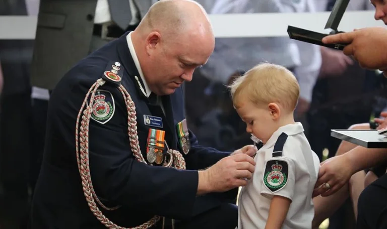 Exciting: Baby gets a father fireman's decoration that died of fires in Australia